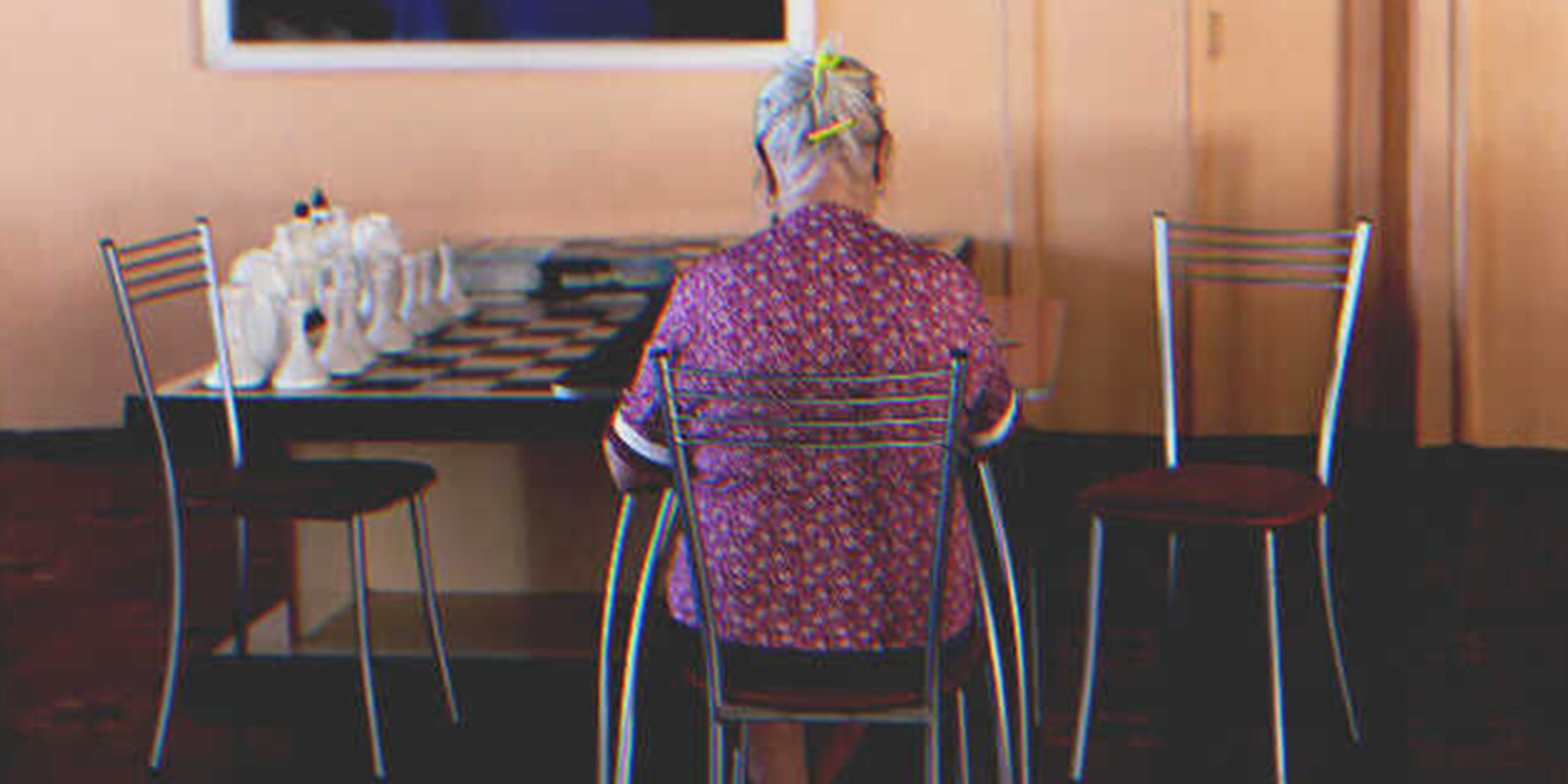 An old woman sitting alone in front of a table | Source: Shutterstock