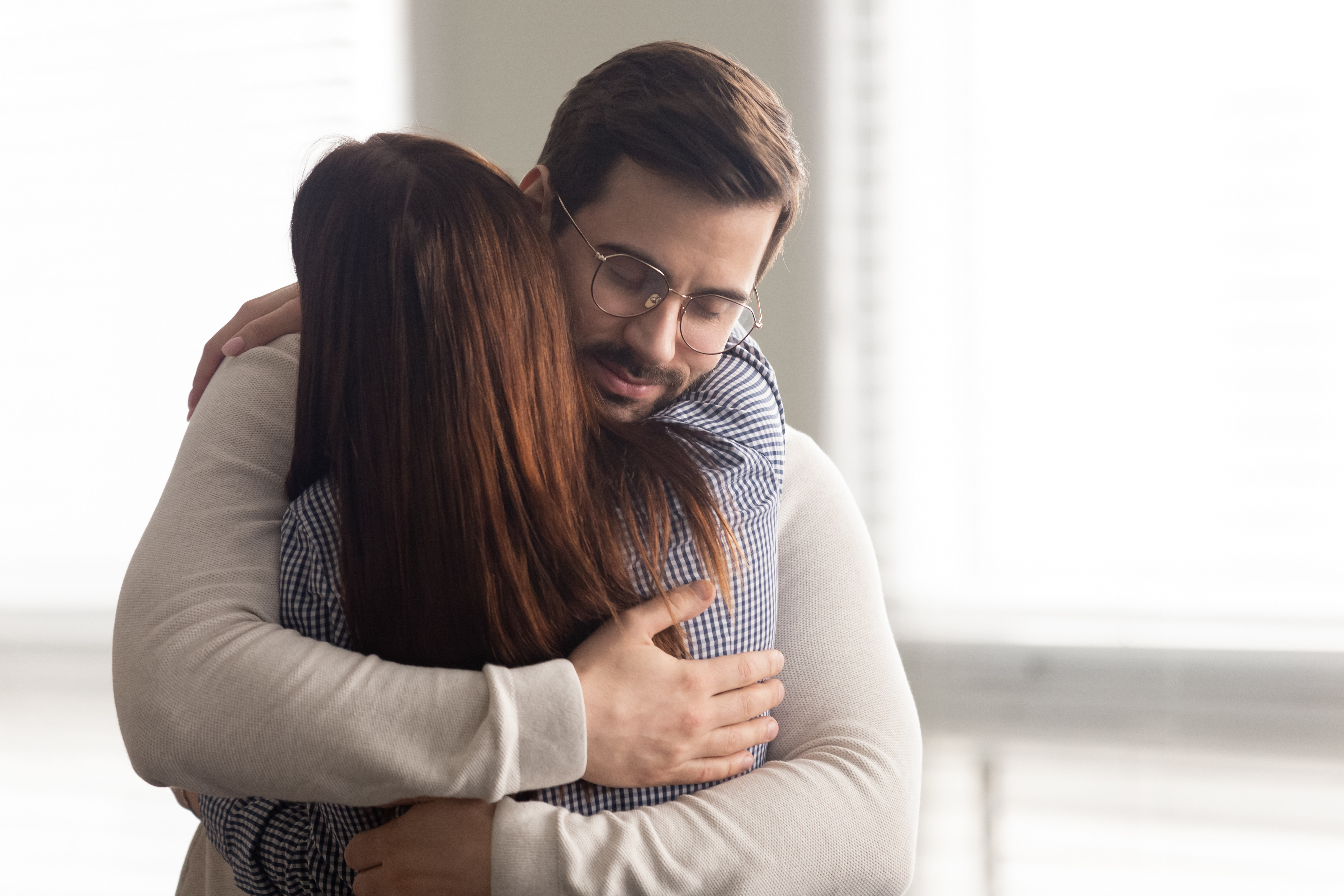 Un hombre abraza a una mujer triste | Fuente: Shutterstock.com