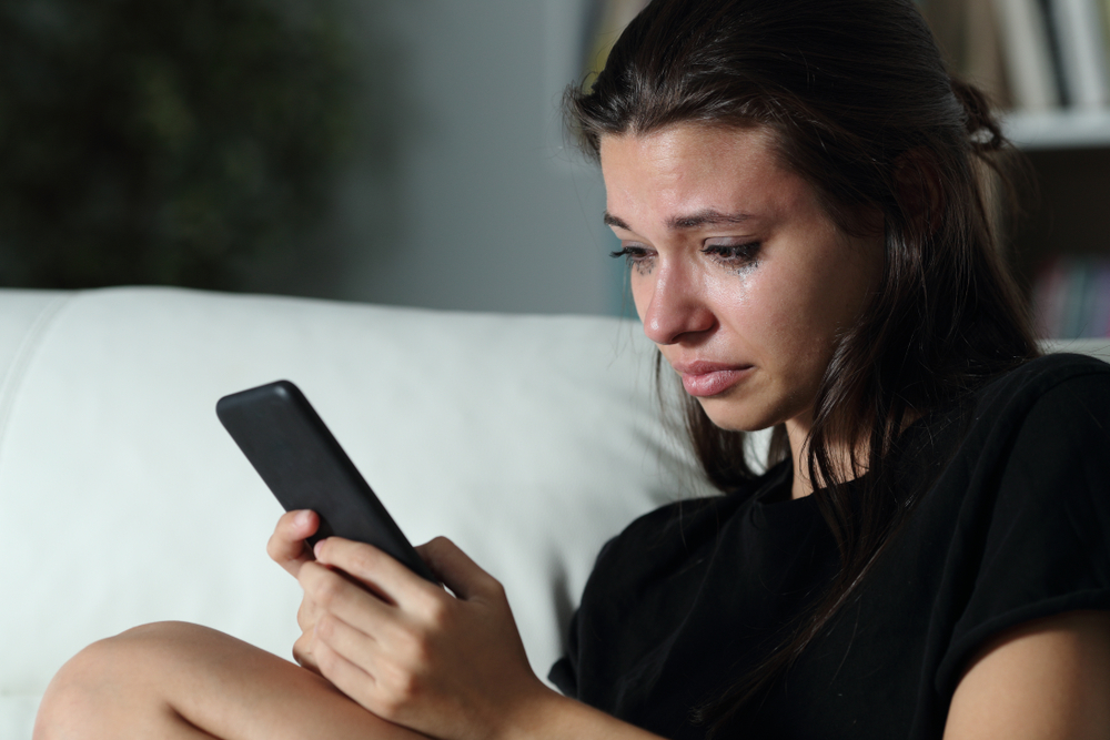 Mujer mirando un teléfono | Imagen: Shutterstock