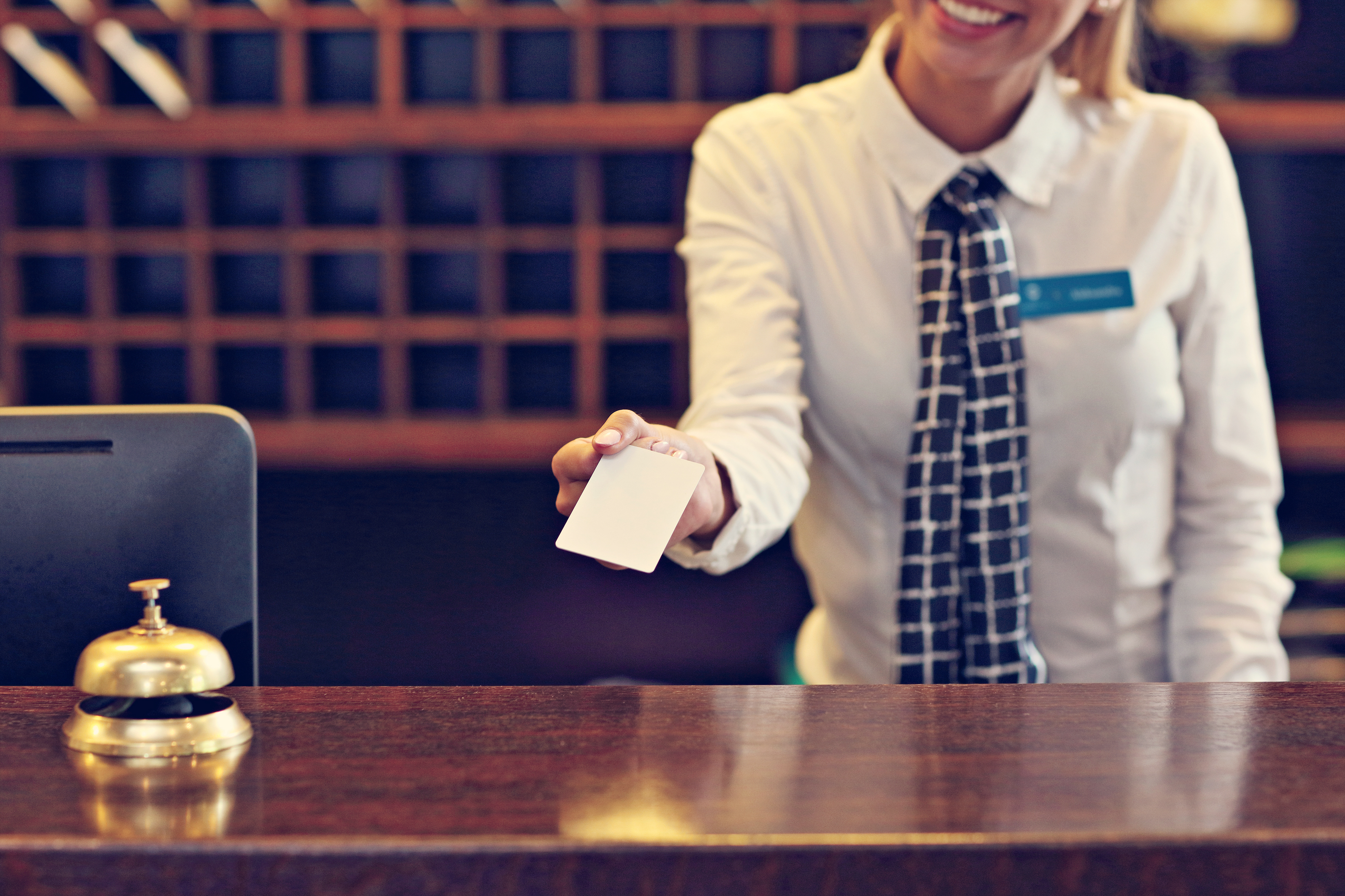 Foto de recepcionista entregando tarjeta llave. | Fuente: Shutterstock