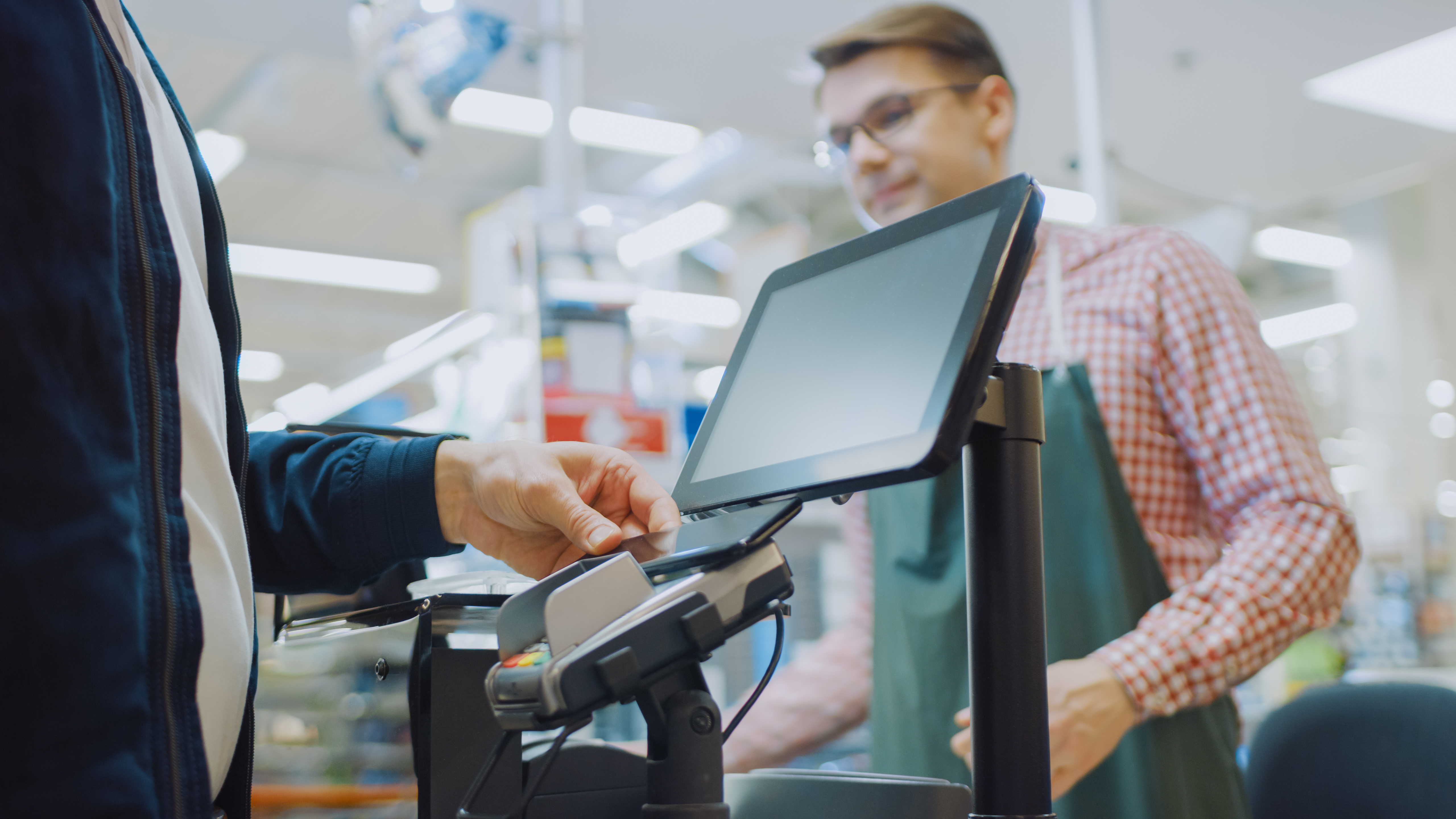 A man standing at the checkout counter of a store | Source: Shutterstock