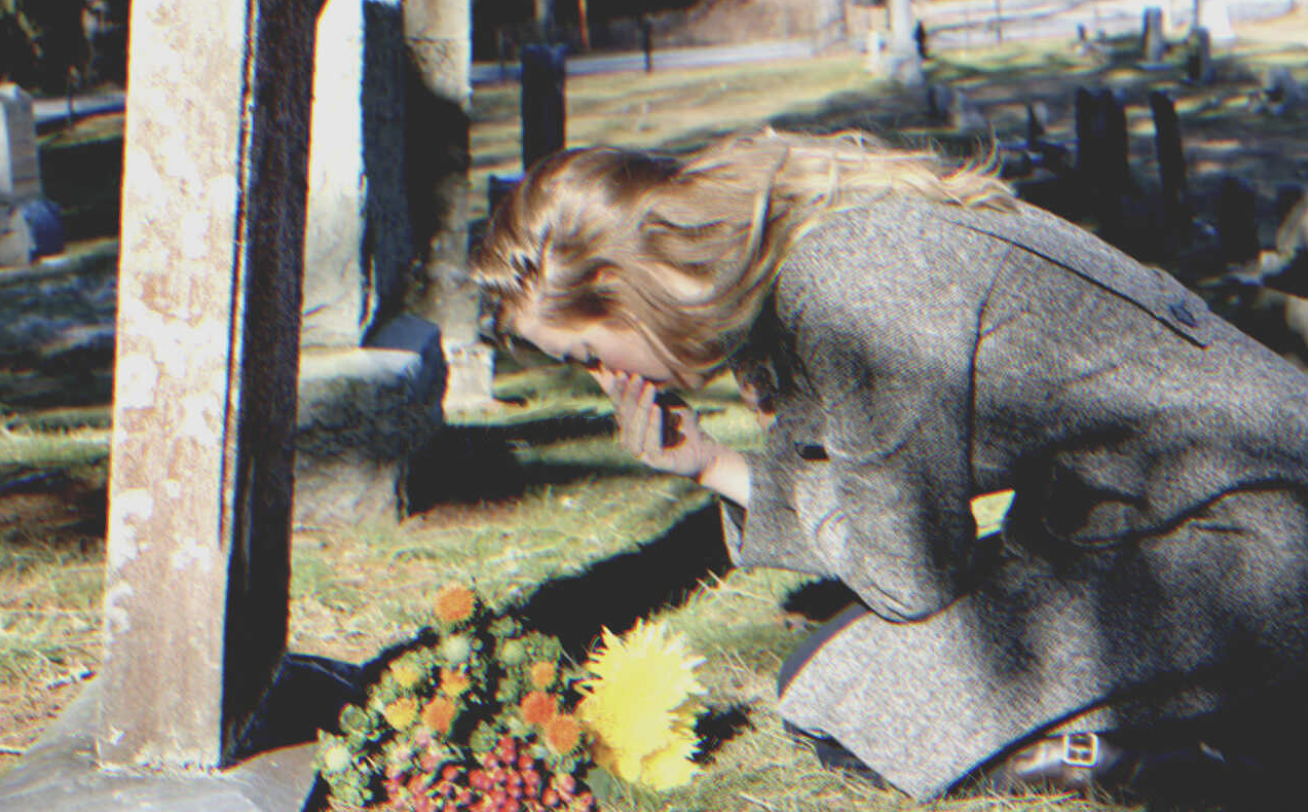 Mujer afligida cerca de una tumba | Fuente: Flickr