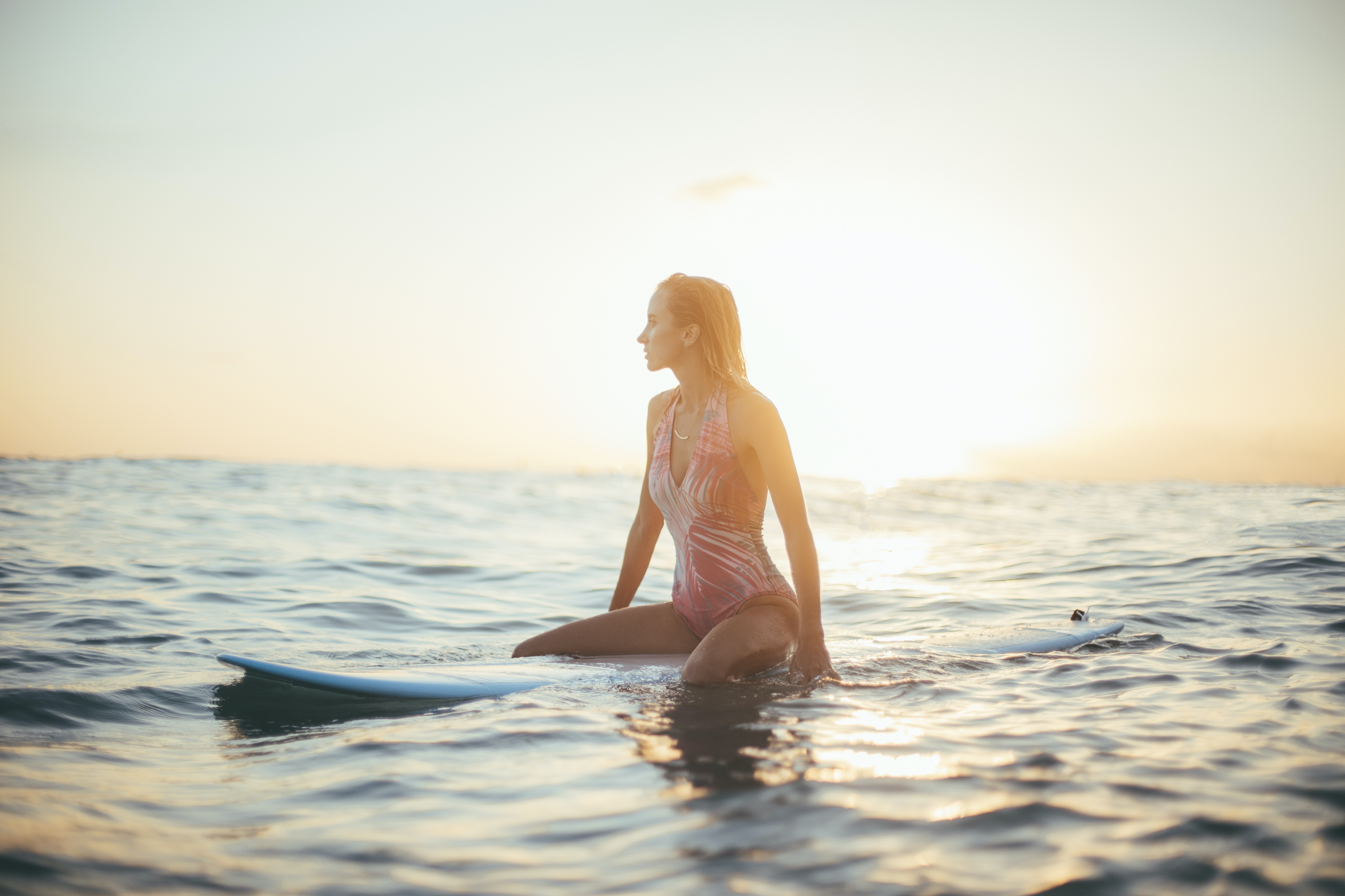 A woman out at sea on a surfboard. | Source: Unsplash