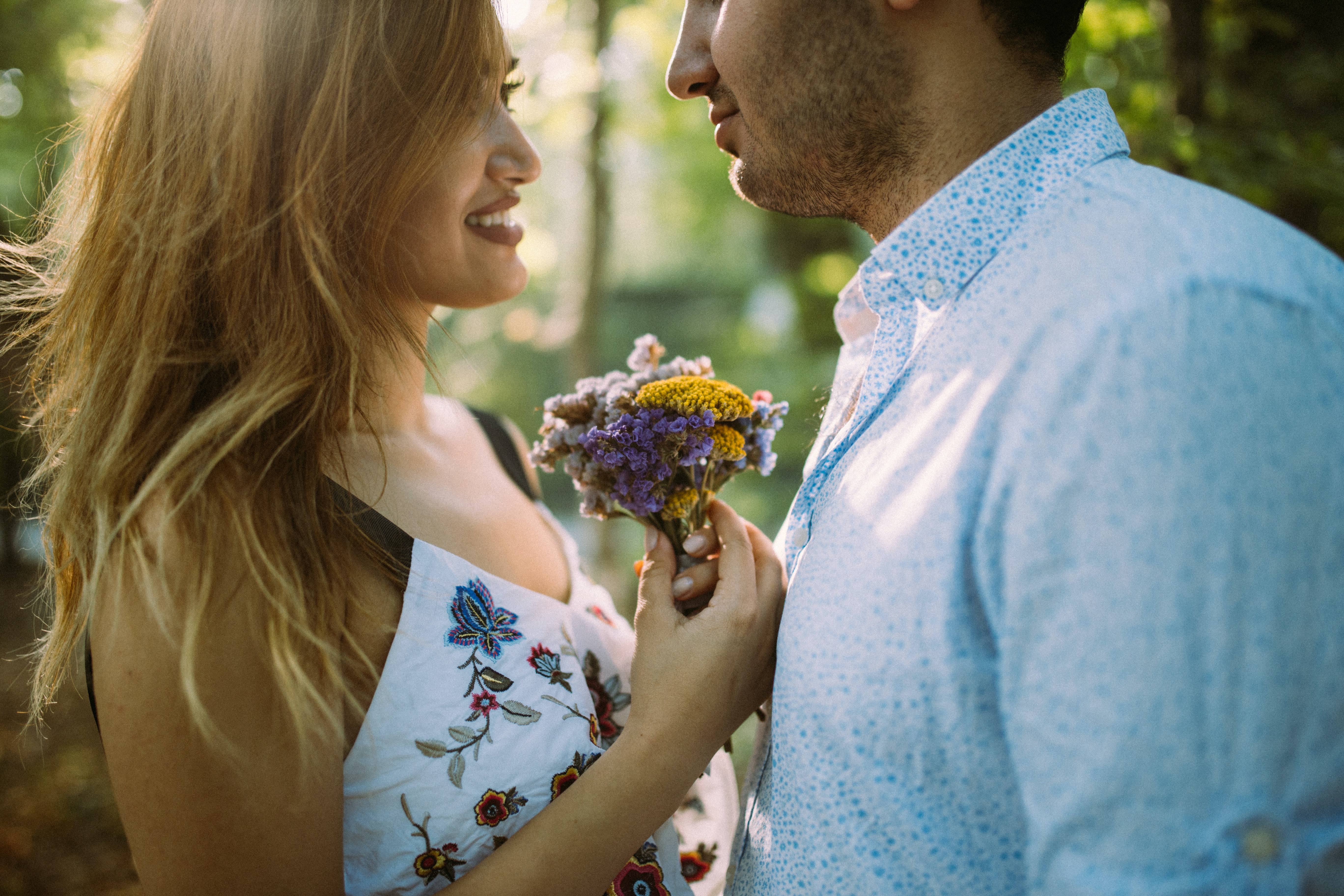 A photo of a man and a woman facing each other while holding flowers | Source: Unsplash