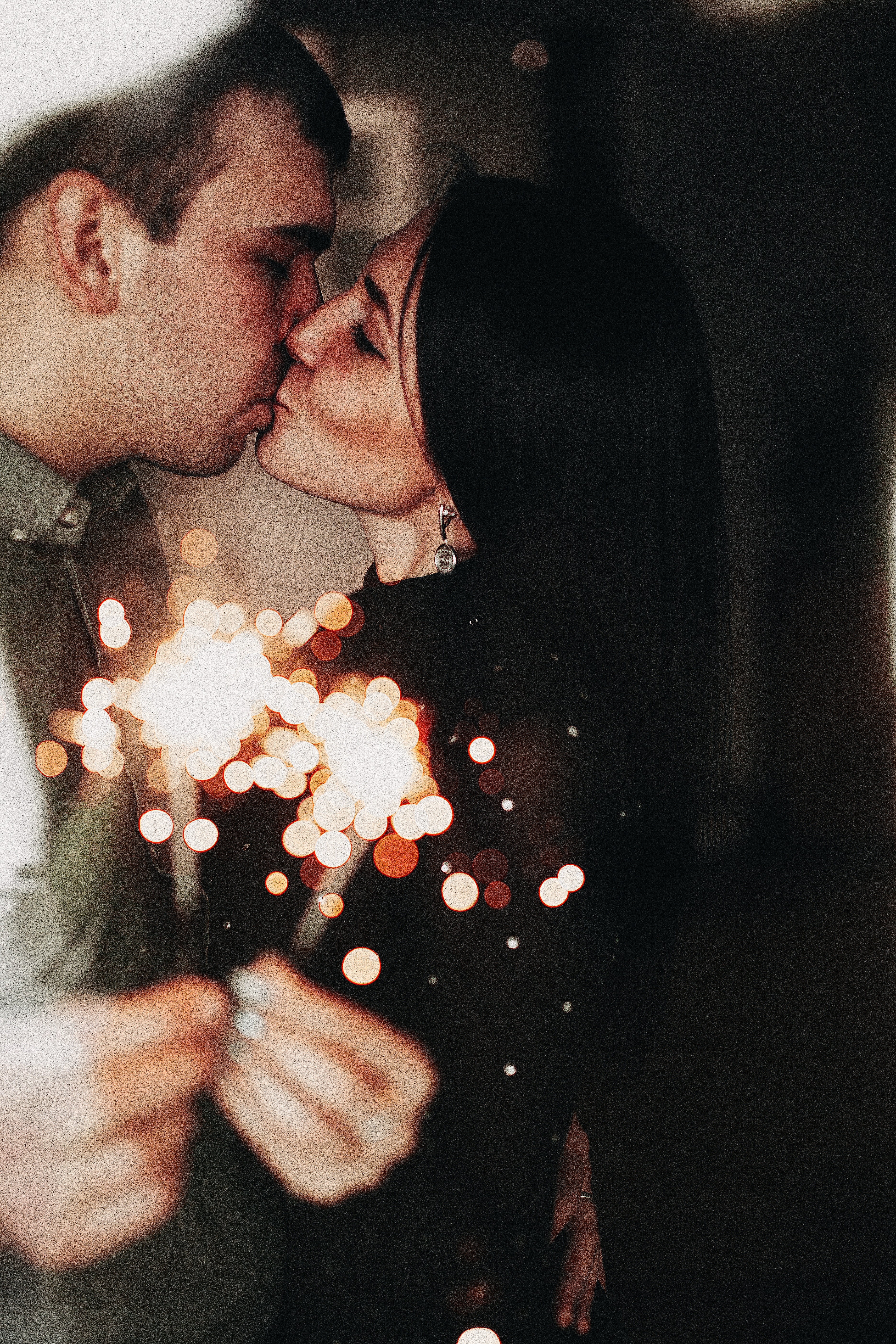 A couple holding sparklers while kissing. | Source: Pexels