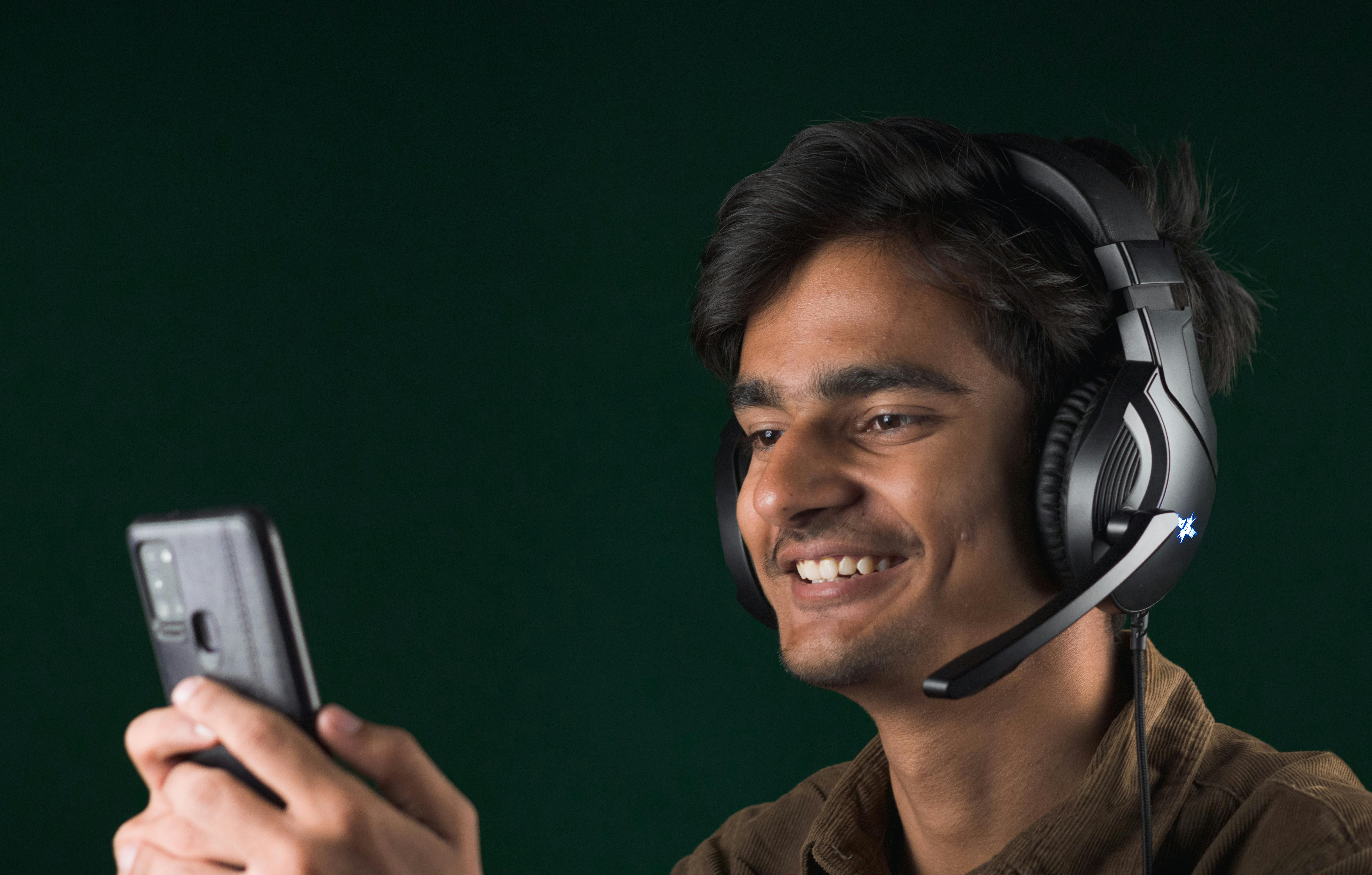 A man smiling at something on his phone, photo taken on May 9, 2023. | Source: Pexels