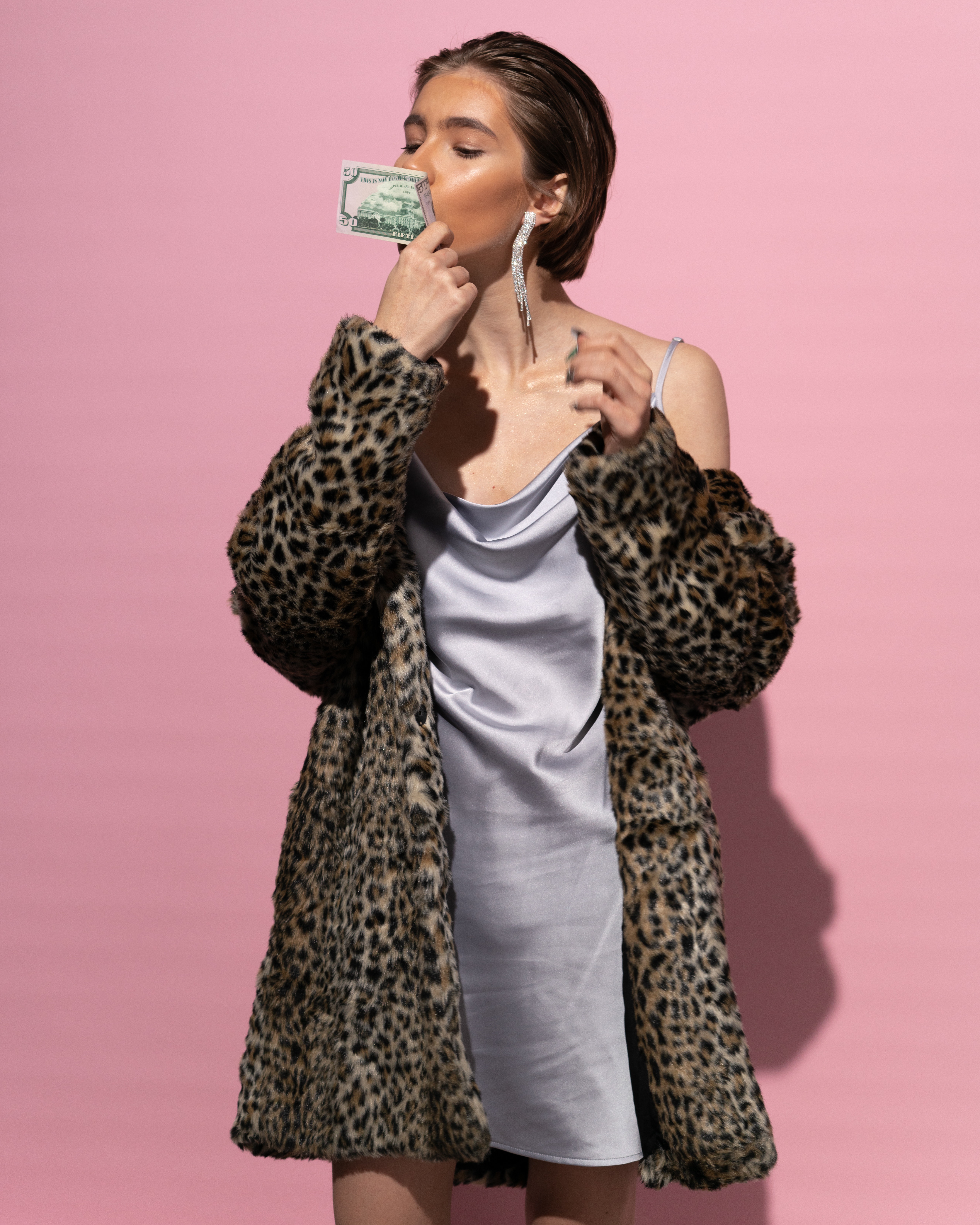 A woman smelling money. | Source: Pexels