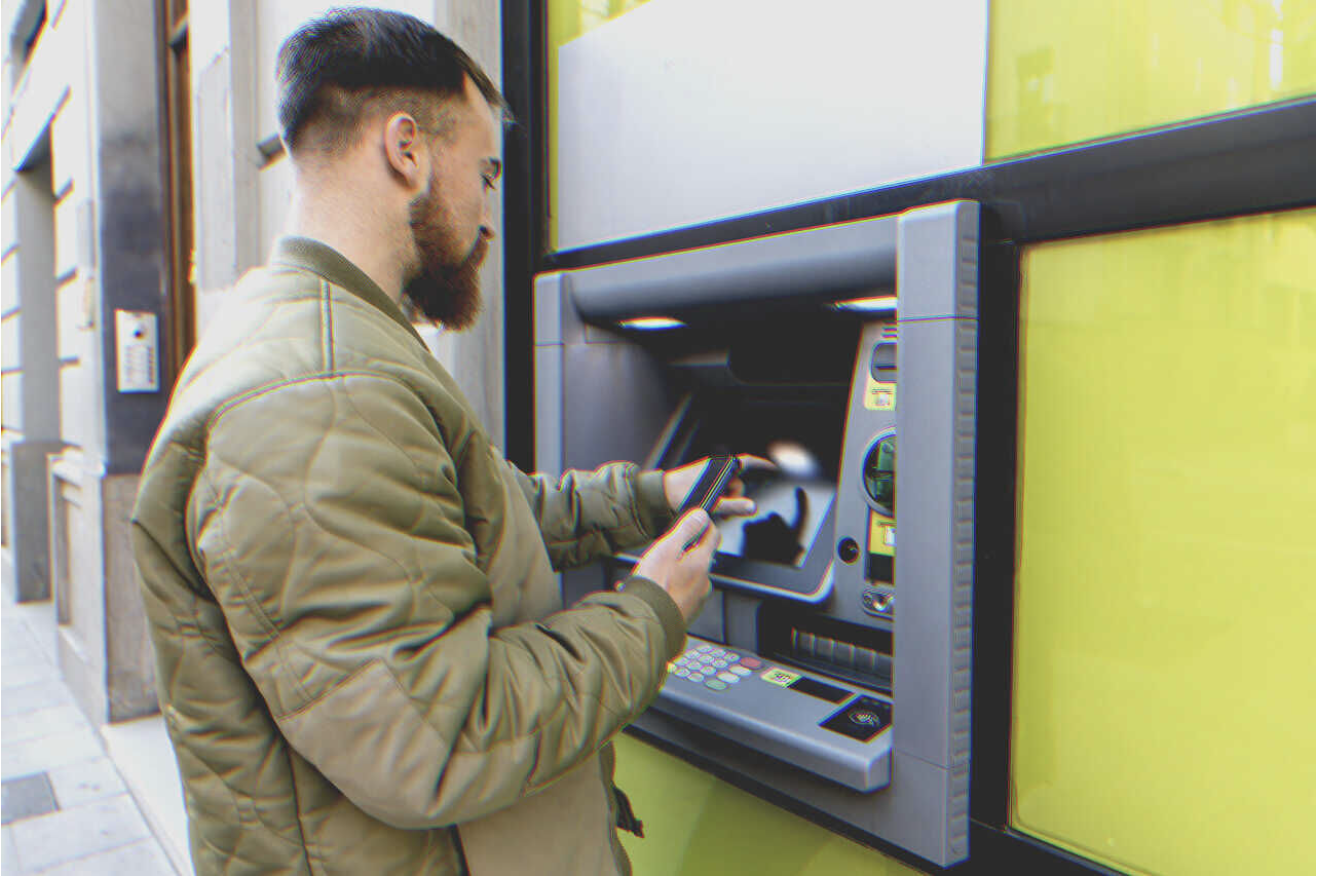 Un hombre saca dinero de un cajero automático | Fuente: Getty Images
