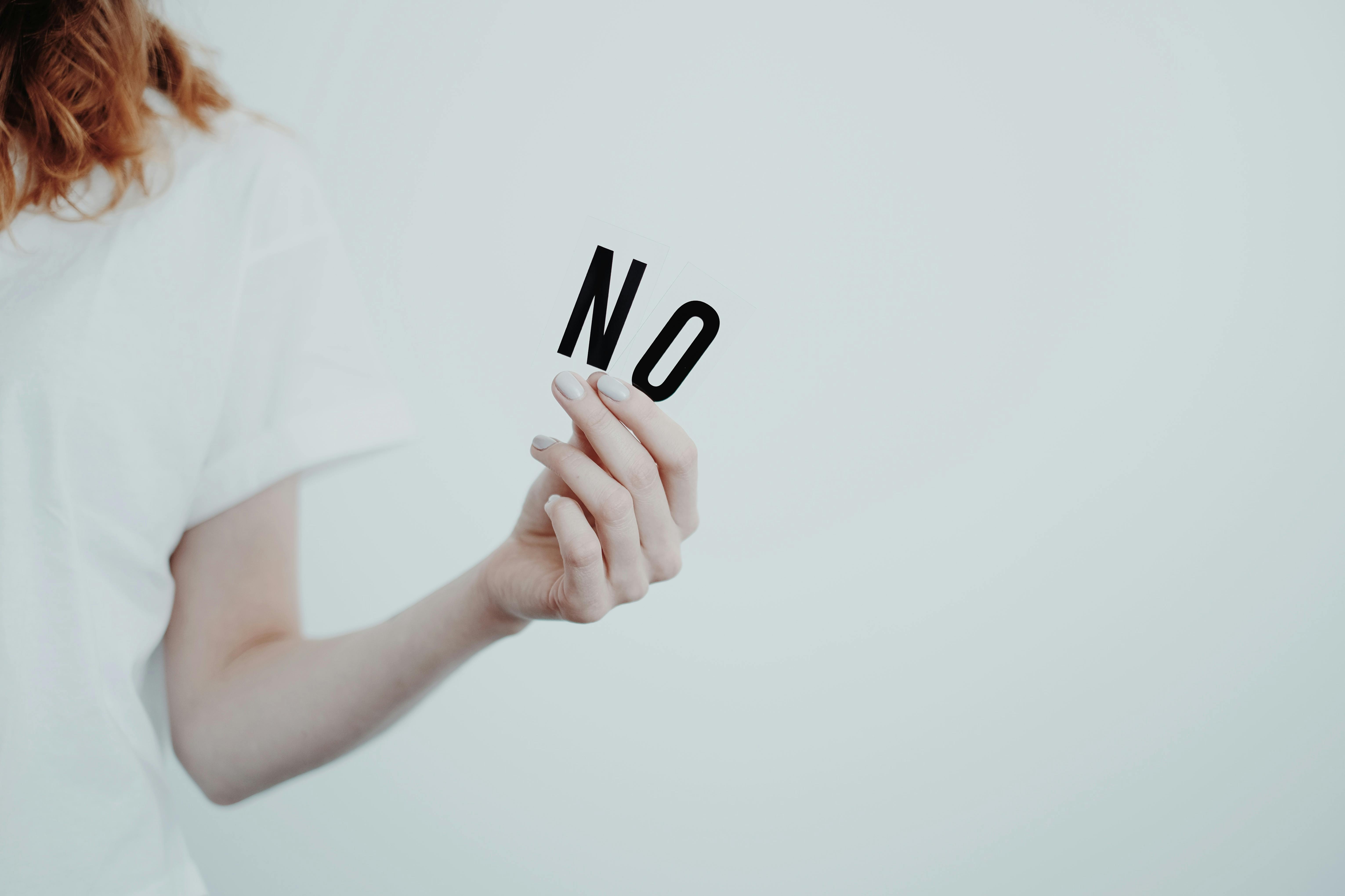 Una persona diciendo no con un cartel. | Fuente: Pexels