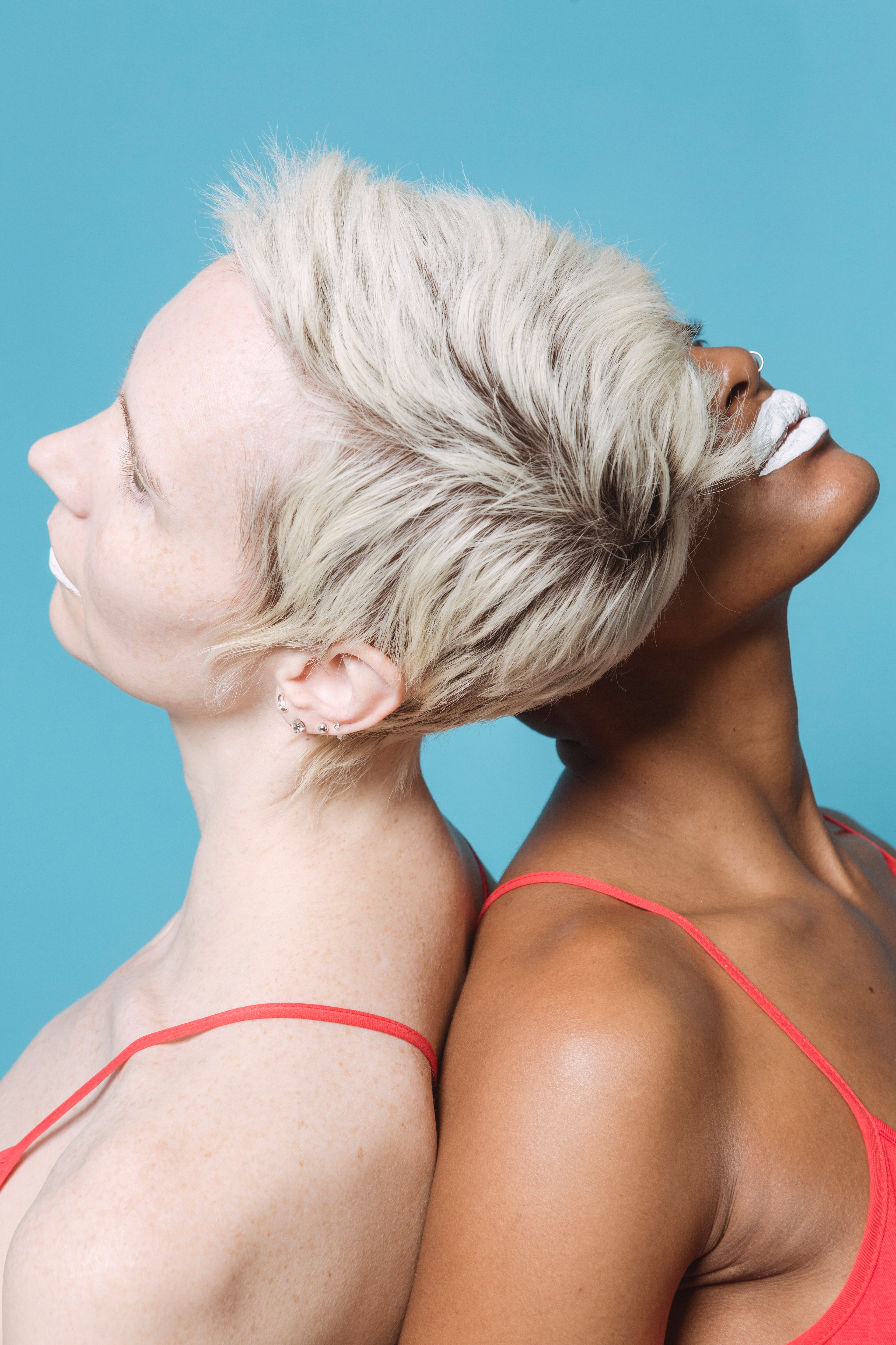 Two woman leaning backward on one another.│ Source: Pexels