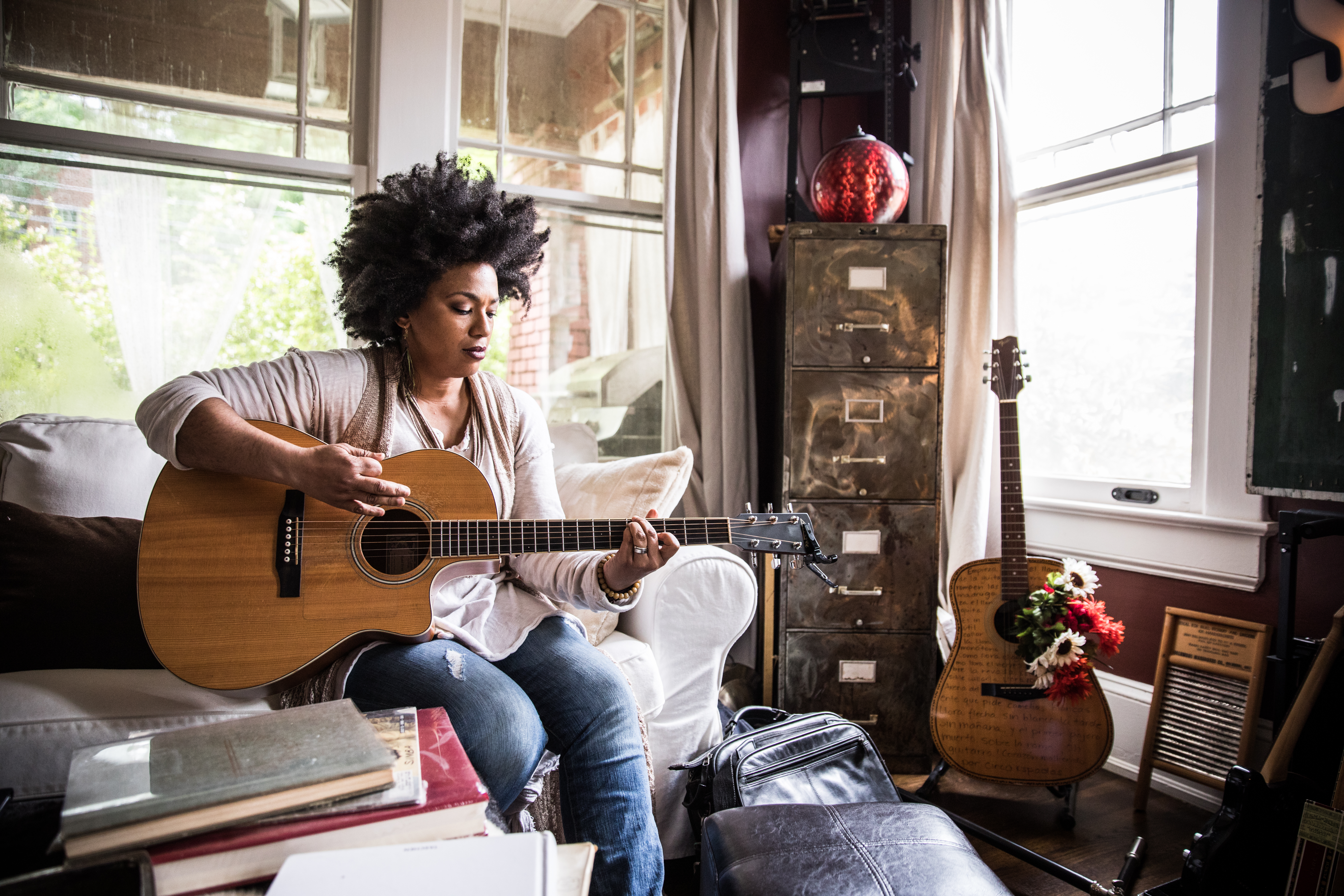 A woman playing guitar alone at home. | Source: Getty Images