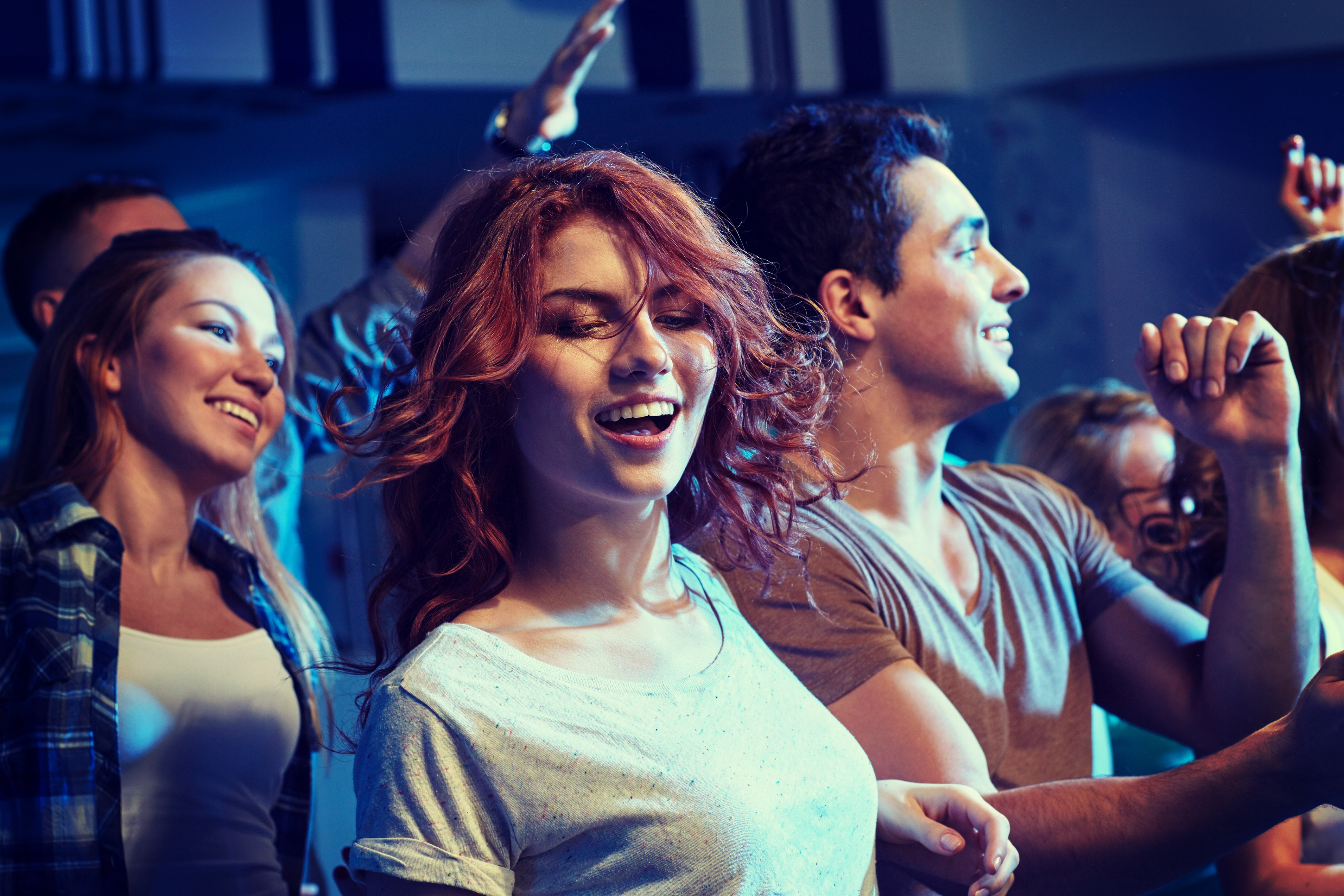 A young woman is pictured dancing with her friends at a party | Source: Shutterstock